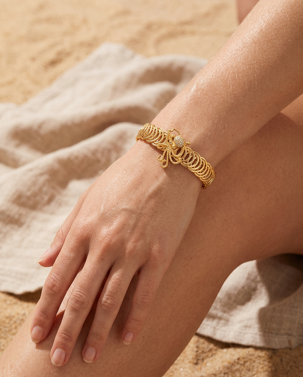 Gold marine starfish bangle worn on the wrist, coastal summer