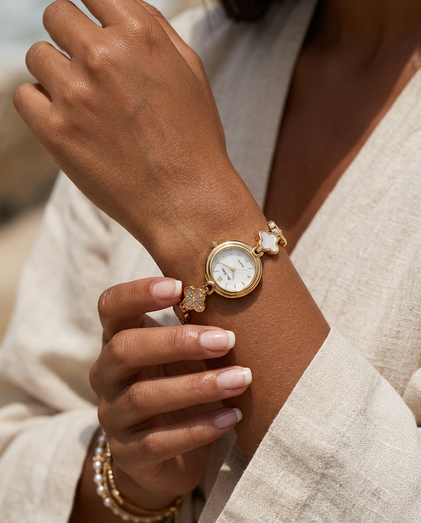 Gold floral-design white-face watch worn on the wrist, summer editorial