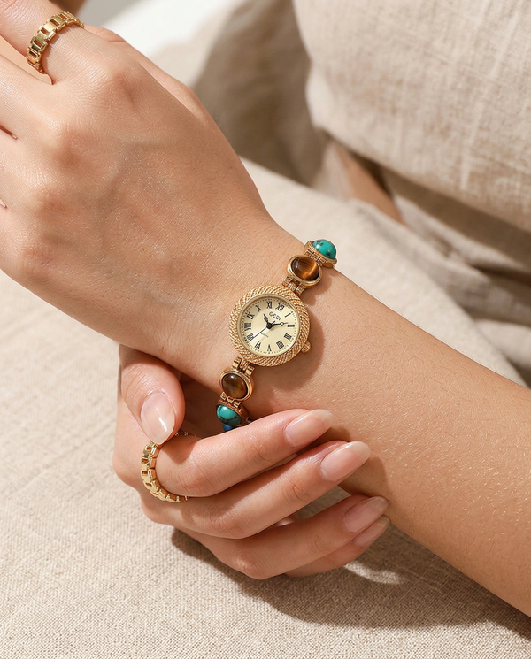 Gold textured-bezel Roman pearl-dial watch worn on the wrist, summer
