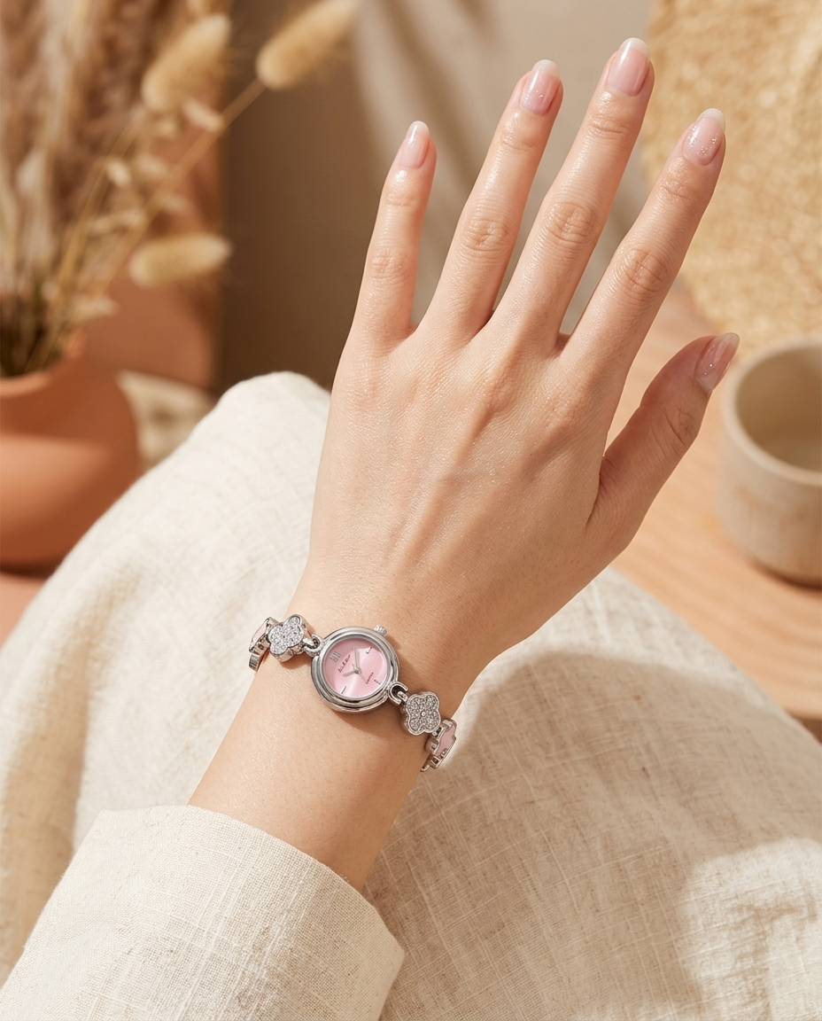 Silver floral-design watch with soft pink face worn on the wrist, summer