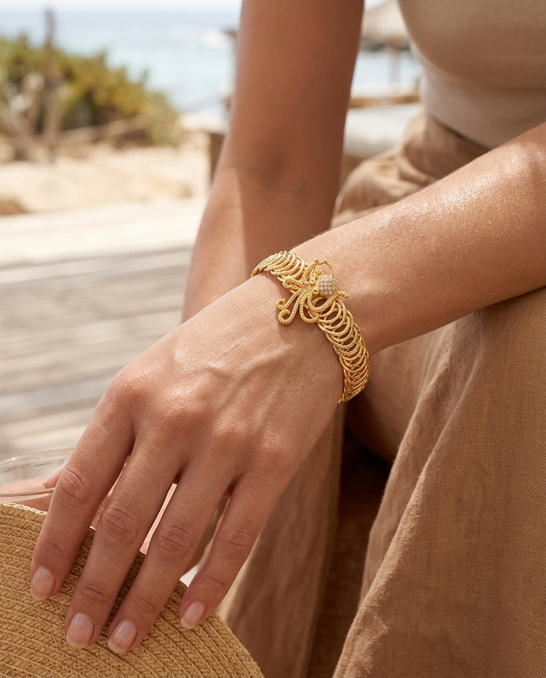 Gold marine cuttlefish bangle worn on the wrist, coastal summer