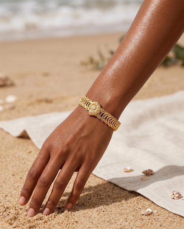 Gold marine starfish and shell bangle worn on the wrist, coastal summer
